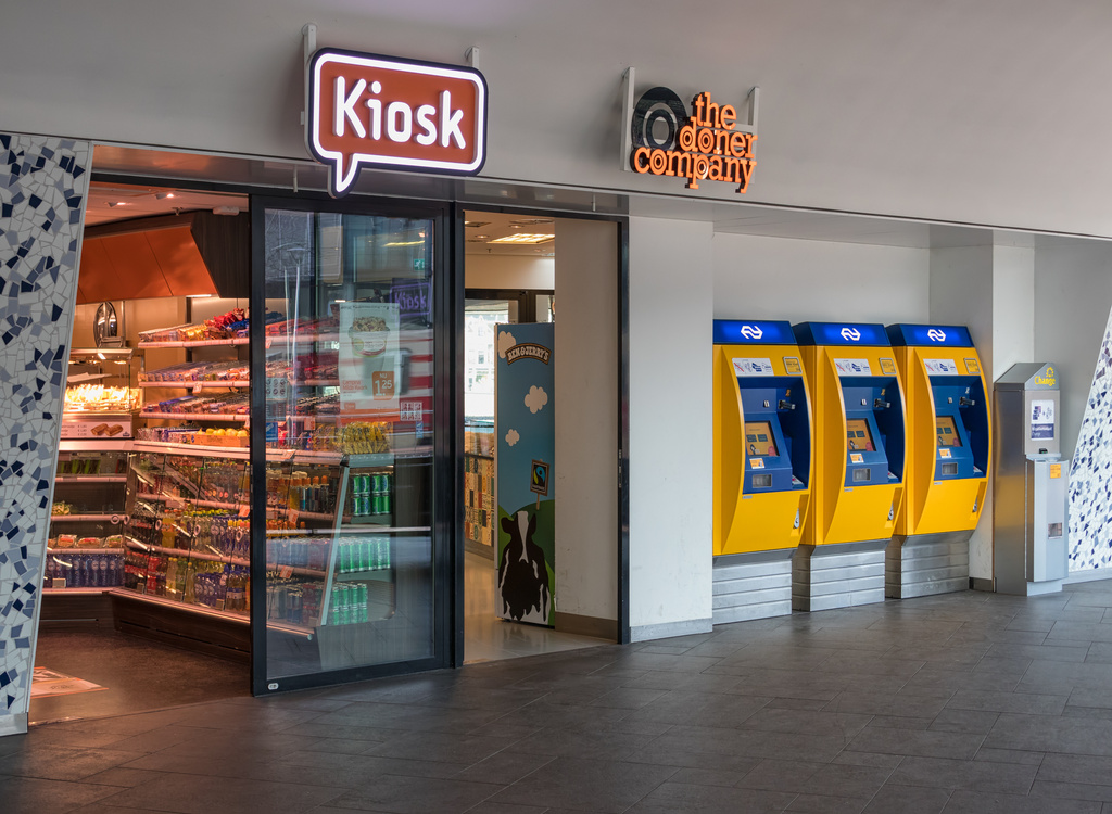 Delft, The Netherlands - march 15, 2018: Kiosk and three yellow ticket machines at Dutch railway station of Delft