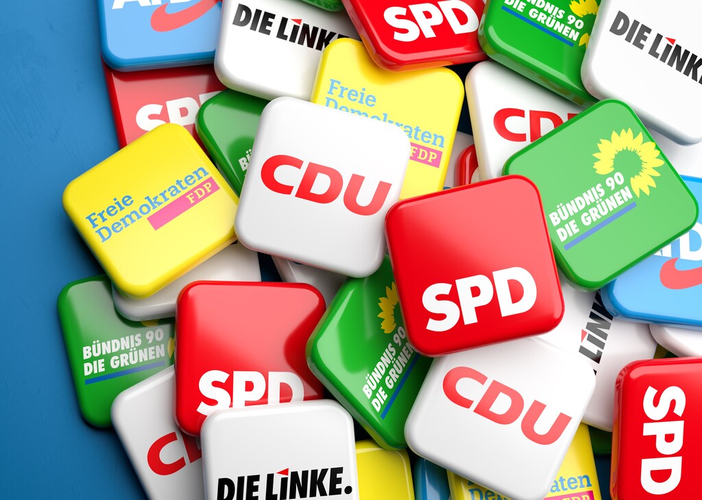 Logos of the biggest German nationwide operating political parties (CDU, SPD, Die Grünen, FDP, Die Linke, AfD) on a heap on a table. Copy space.